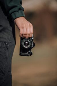 men picking up camera in hand