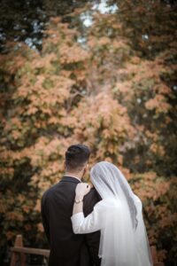 wedding couple giving pose and surrounding tree